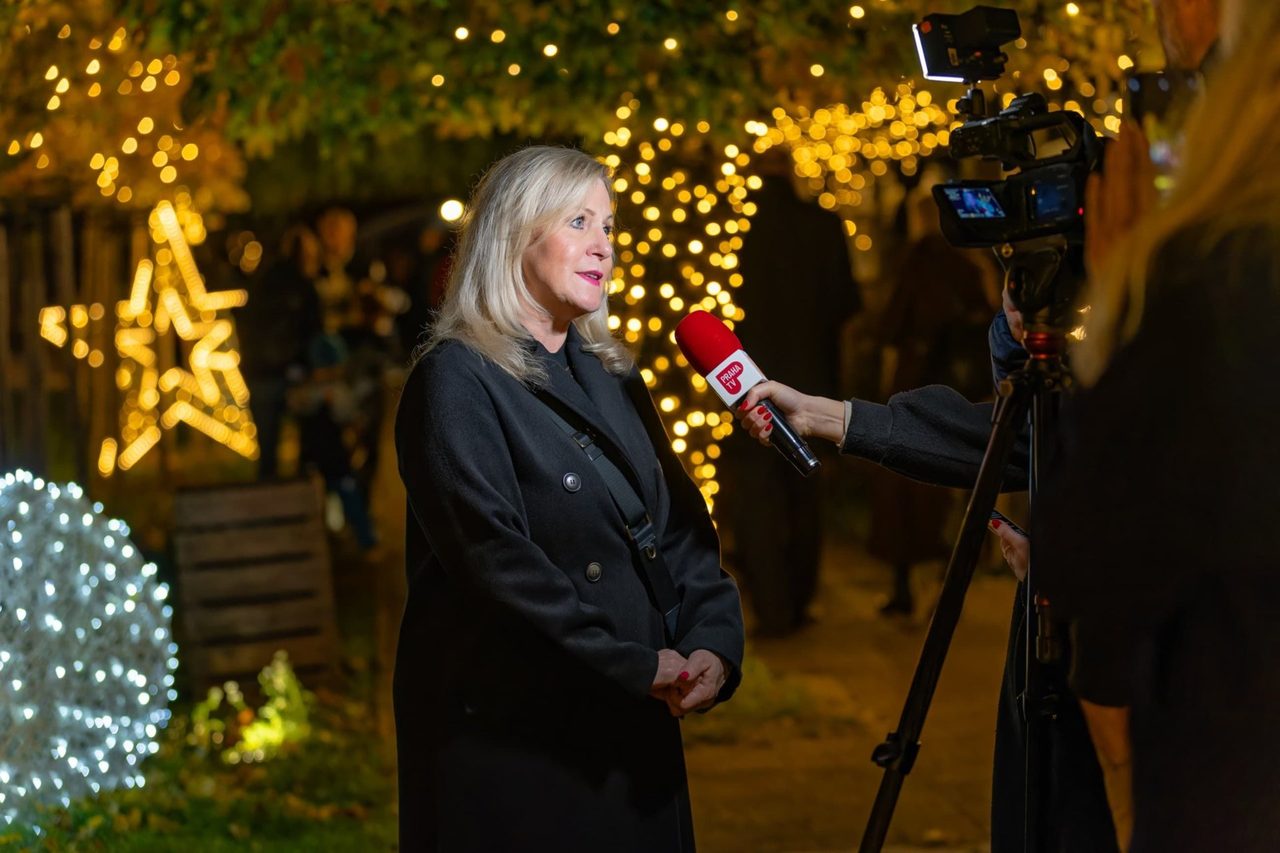 Eva Poláčková při rozhovoru pro televizi mezi světelnými dekoracemi