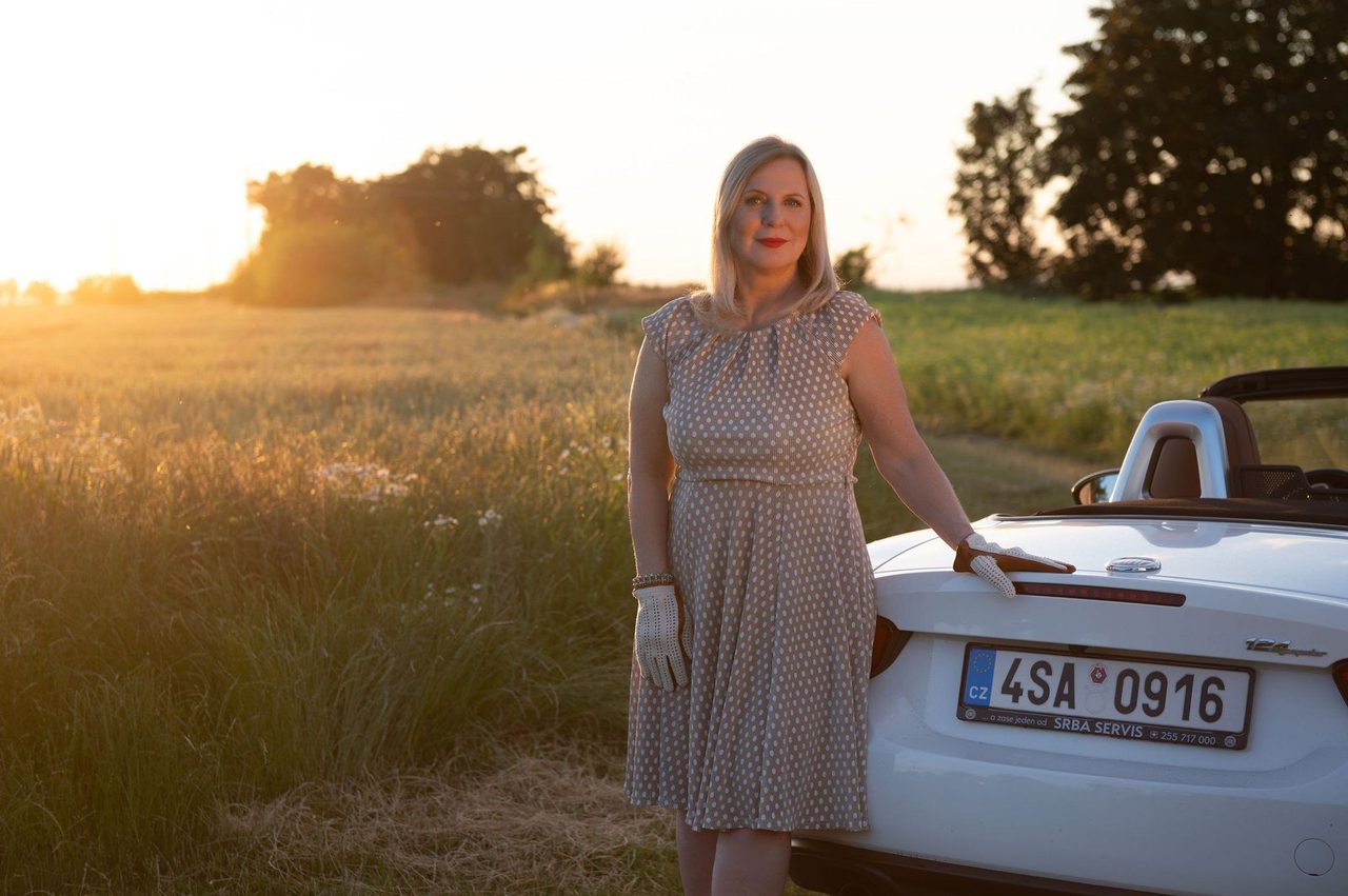 Eva Poláčková u bílého kabrioletu v poli