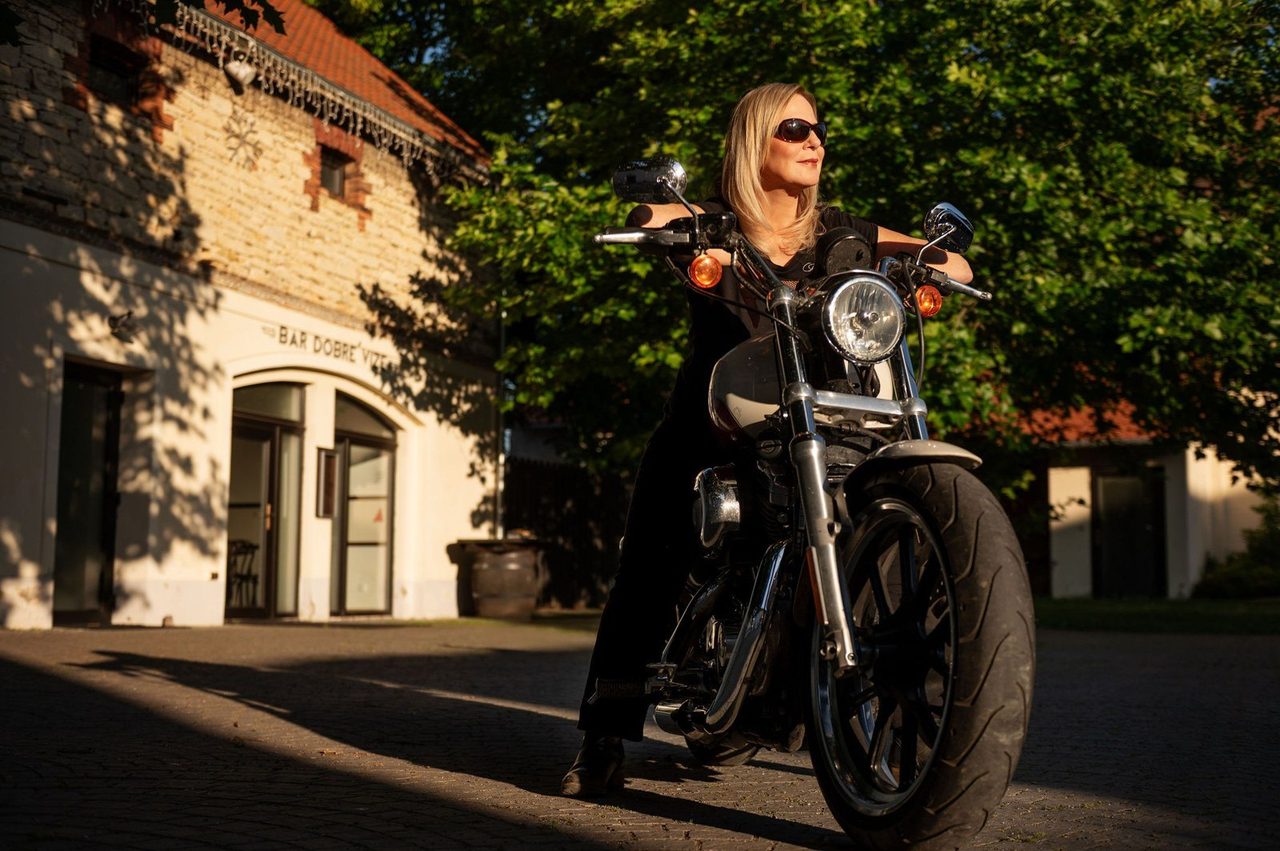 Eva Poláčková na motorce před budovou