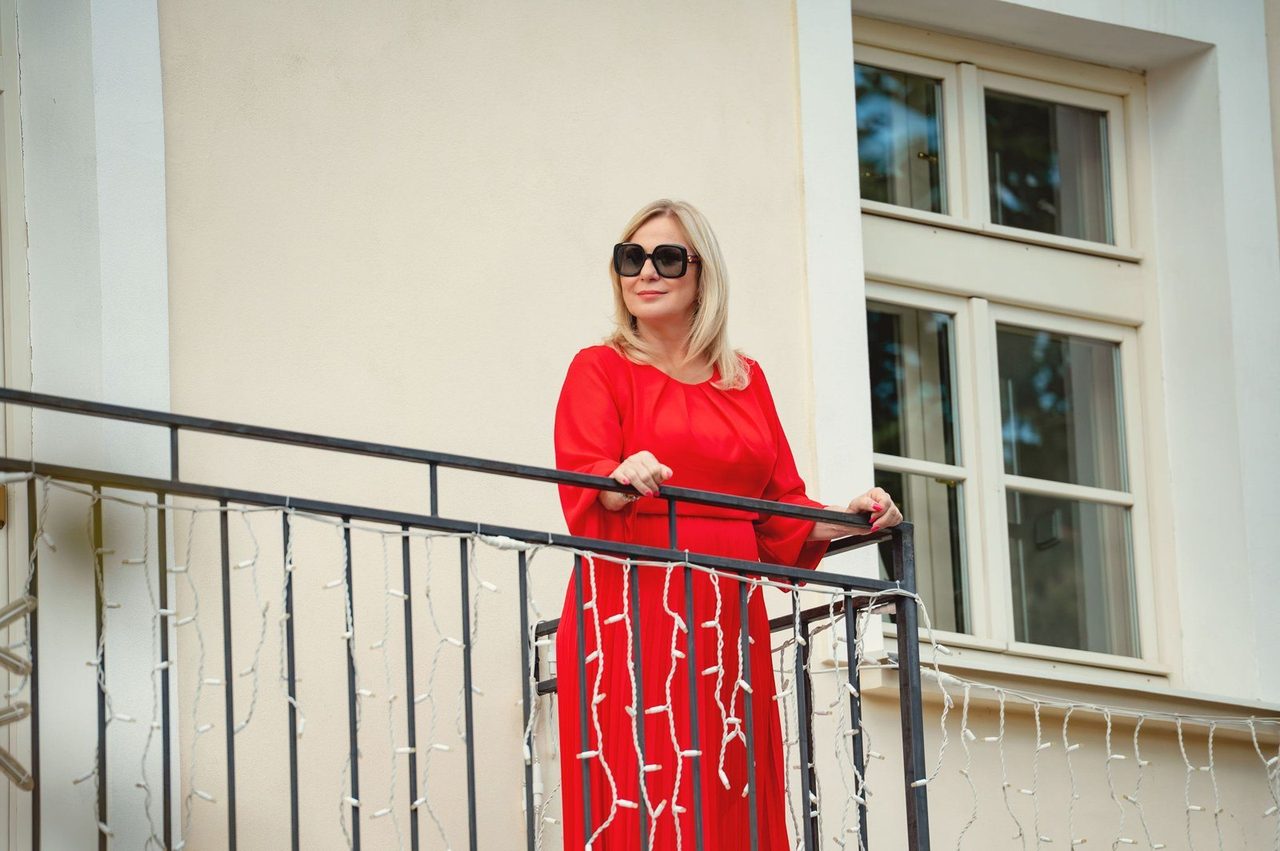 Eva Poláčková v červených šatech u zábradlí